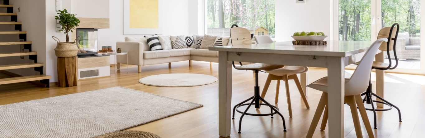 Sala de estar moderna con decoración escandinava, comedor de madera y gran ventanal al jardín